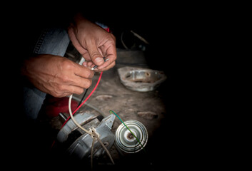 The mechanic's hand is repairing the electric motor. And there is a black space