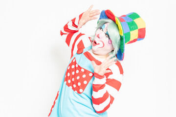 白背景の前で驚いたジェスチャーをするピエロ