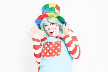 白背景の前で驚いたジェスチャーをするピエロ