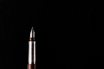 Top close up shot of one fountain pen with the cap opened placed over black background.