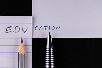 Top shot of a pen and pencil with education word written by both in half -mental growth concept.