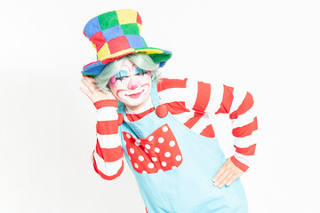白背景の前で耳を澄ますジェスチャーをするピエロ