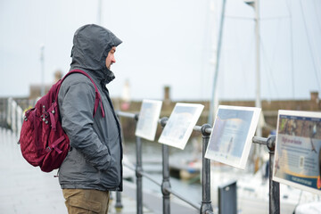 Tourist exploring Whitehaven harbour in Cumbria, England, UK.
