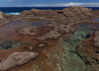 Gran Canaria, calm natural seawater pools in under the steep cliffs of the north coast, separated from the ocean by 
volcanic rock, Punta de Galdar area