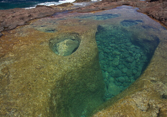 Gran Canaria, calm natural seawater pools in under the steep cliffs of the north coast, separated from the ocean by 
volcanic rock, Punta de Galdar area