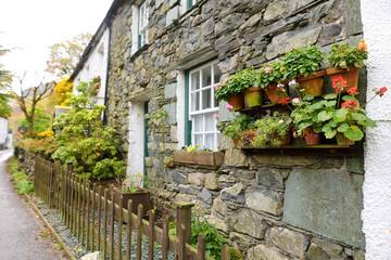 Fototapeta na wymiar Houses of Stonethwaite village, beautifully decorated with flowers and greenery. Small village situated in the valley of the Stonethwaite Beck, Cumbria, UK.