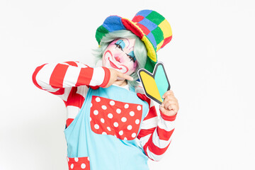 白背景の前に立って、初心者マークを持つピエロ