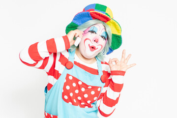 白背景の前に立って、電話を使うピエロ