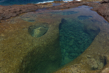 Gran Canaria, calm natural seawater pools in under the steep cliffs of the north coast, separated from the ocean by 
volcanic rock, Punta de Galdar area
