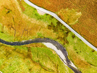 Aerial view of Honister Pass, a mountain pass with a road winding along Gatesgarthdale Beck mountain stream. Cumbria, the Lake District, England.