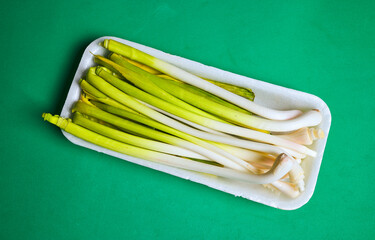 Tray with garlic, they belong to the lily family, such as onion and leek. They are the young plant of garlic