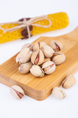 pistachios in shell, fried, on a wooden board, on a white background