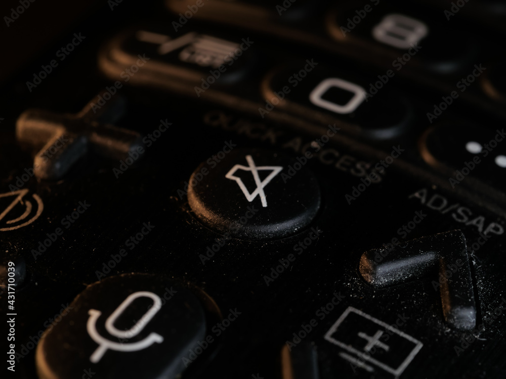 Poster selective focus shot of remote control with different buttons for the tv in the black background