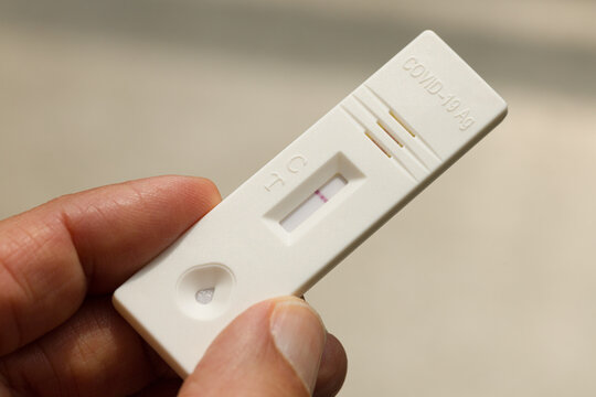 Close up of a hand holding rapid covid -19 test with a negative result. Express self-test coronavirus testing at home.