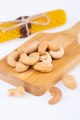 cashew nuts, fried, large, on a wooden board, on a white background