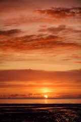 Obraz premium Beautiful sunset colors over the coastline of Allerdale district in Cumbria, UK. Sun setting over the shore of Allonby bay on autumn.