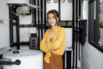 A portrait of young housewife standing in the boiler room at home.