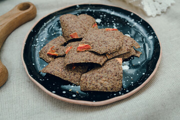 Layout of linen breads with chilly pepper on spotted ceramic plate.