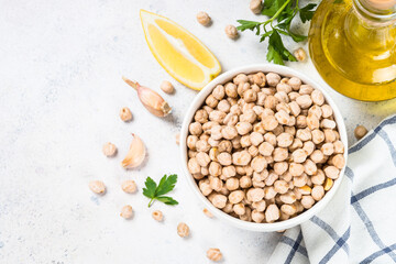 Chickpeas in white bowl at light kitchen table.
