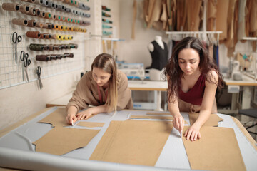 female tailors working with sewing pattern in atelier studio workshop