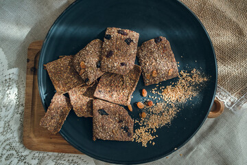 Layout of linen breads with raisins on a black plate. 