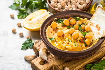 Hummus with olive oil and paprika at light kitchen table.