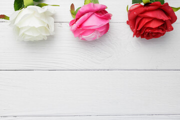 Flat lay, top view beauty red, pink, and white rose flowers on vintage wooden background with copy space. Day of love concept such as valentine's day, mother's day, and wedding.