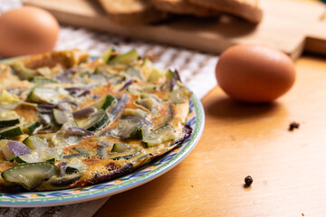 Zucchini and onion omelette served with bread. Complete vegetarian dish.
