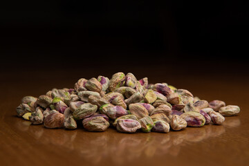 Bunch of peeled pistacios on a wooded table