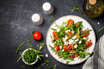 Arugula salad with tomatoes and blue cheese at black.