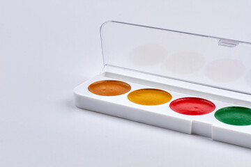 Set of watercolor paints in box isolated on white background.
