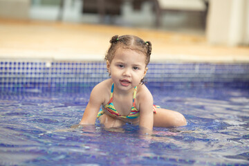 Child having fun in the pool, with space for text.