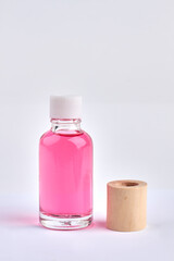 Small glass bottle with pink liquid and medical adhesive tape.