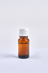 Small brown medical bottle with liquid. Isolated on white background.
