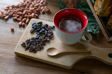 Cup of cacao drink with fresh cocoa pods, cocoa beans on wooden table, top view, Cacao fruits which is used as raw material to make chocolate