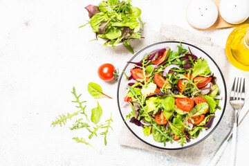 Green salad with fresh vegetables at white.