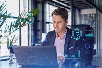 Handsome businessman in suit at workplace working with laptop to optimize development by implying...