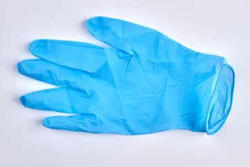 Surgical latex glove on white background. Blue medical glove close up.