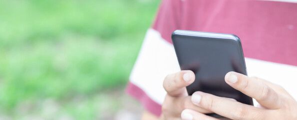 Hand holding and using smartphone.