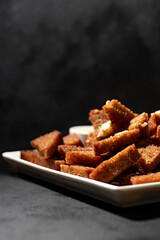 meal. garlic croutons made from black bread on a dark background