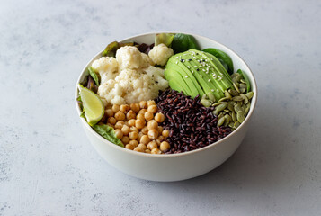 Bowl with avocado, black rice, chickpeas, cabbage, spinach and salad. Healthy eating. Vegetarian food.