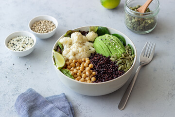 Bowl with avocado, black rice, chickpeas, cabbage, spinach and salad. Healthy eating. Vegetarian food.