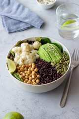 Bowl with avocado, black rice, chickpeas, cabbage, spinach and salad. Healthy eating. Vegetarian food.
