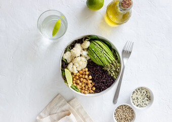 Bowl with avocado, black rice, chickpeas, cabbage, spinach and salad. Healthy eating. Vegetarian food.