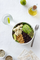 Bowl with avocado, black rice, chickpeas, cabbage, spinach and salad. Healthy eating. Vegetarian food.