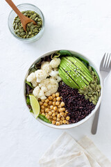 Bowl with avocado, black rice, chickpeas, cabbage, spinach and salad. Healthy eating. Vegetarian food.
