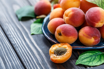 Delicious ripe apricots in a wooden bowl on the table close-up.Healthy fruits. Horizontal top view. Free space for your text.
