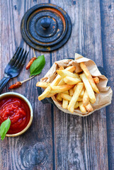
 Crispy  deep fried     turkey nuggets and ketchup. Breaded  turky efillets  with chilly peppers and fresh basi on wooden rustic background