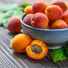 Delicious ripe apricots in a wooden bowl on the table close-up.Healthy fruits. Horizontal top view. Free space for your text.