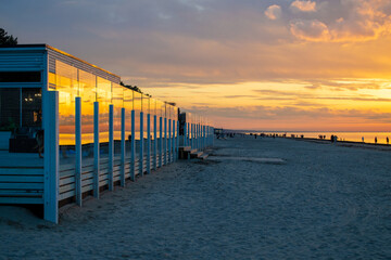 Cafe on beach during sunset. Beautiful colorful clouds over Baltic sea in Jurmala resort, Latvia. Relax, vacation concept.